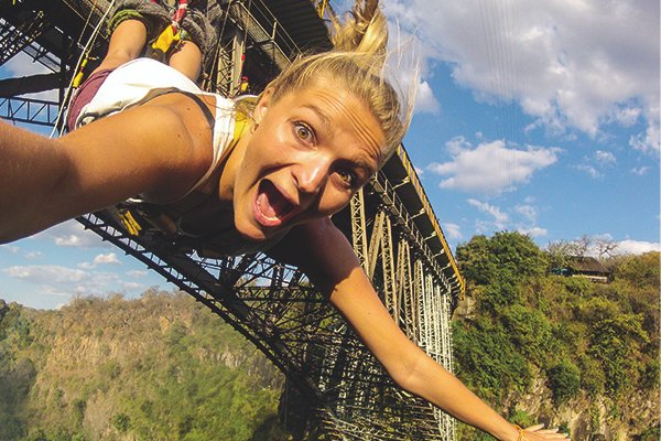 In the heart of Africa adventures at Victoria Falls, Zimbabwe, a courageous lady takes on the ultimate adrenaline rush: the gorge swing. With a sheer drop from the top of the gorge, she embraces the exhilaration, feeling the rush of freedom as she swings over the breathtaking abyss.